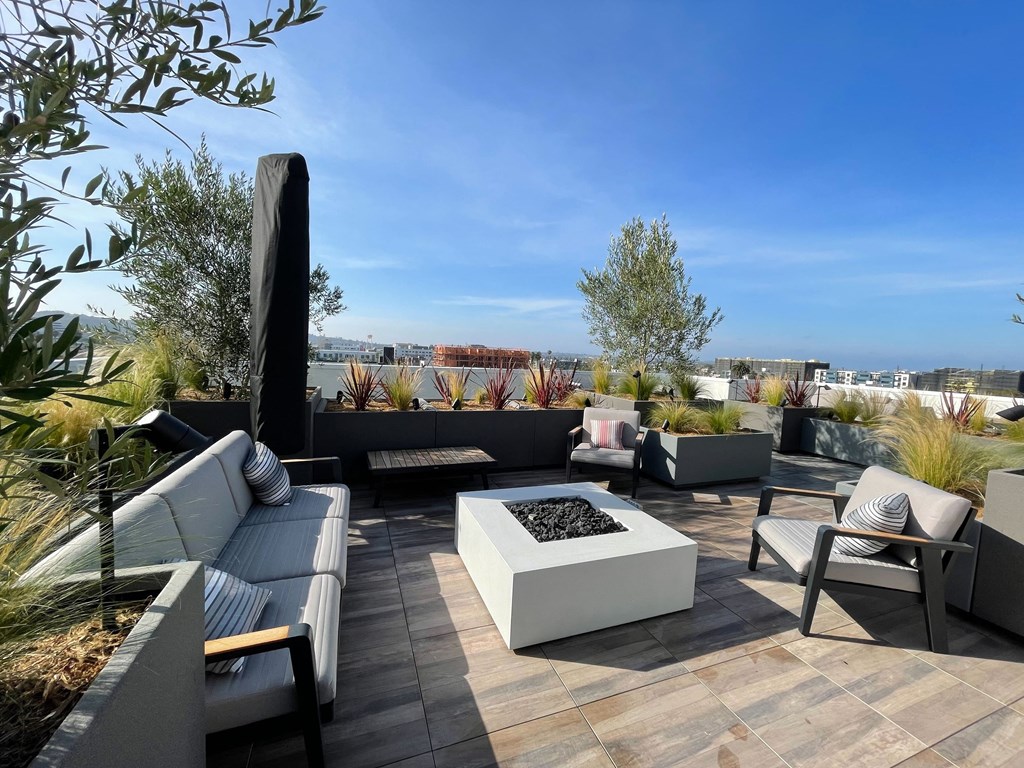 a roof terrace with couches and a fire pit