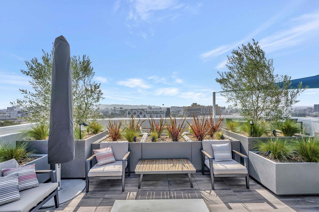 a roof terrace with furniture and a view of the city