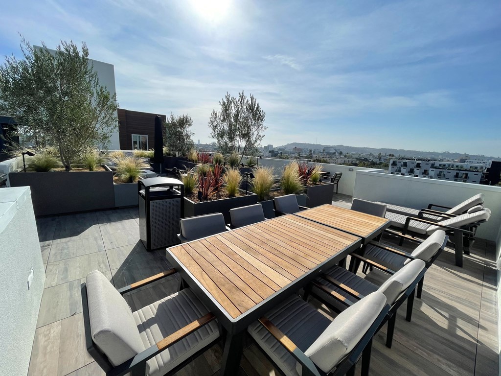 a communal terrace with a table and chairs on a roof