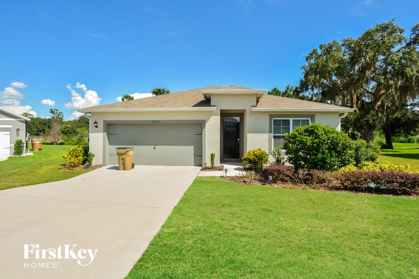 A house with a garage and a driveway in front of it.