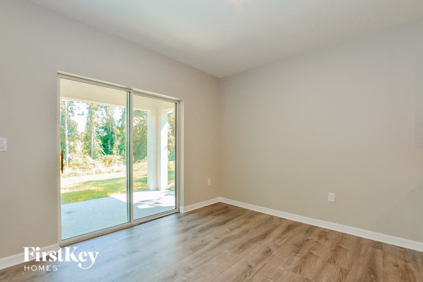 A room with a sliding glass door leading to a backyard.