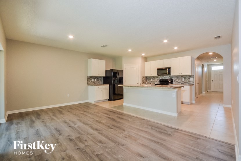 A spacious kitchen with a refrigerator, microwave, and oven.