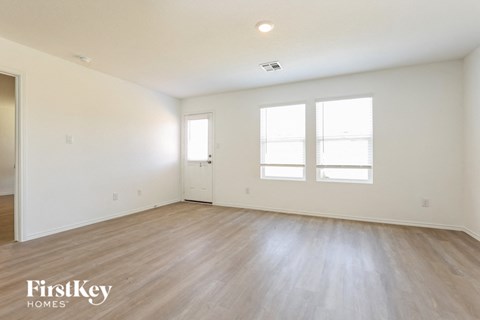 an empty living room with white walls and wood floors
