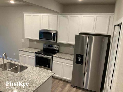 a kitchen with white cabinets and a stainless steel refrigerator