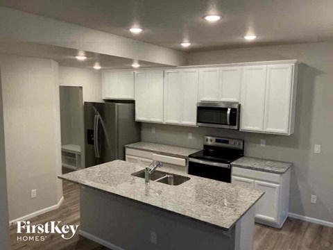an updated kitchen with white cabinets and granite counter tops
