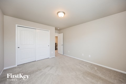 a bedroom with a closet and a door to a hallway