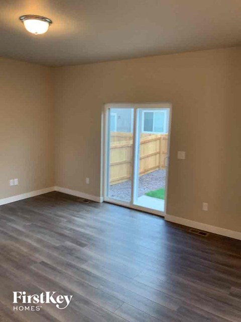 an empty living room with a sliding glass door to a patio