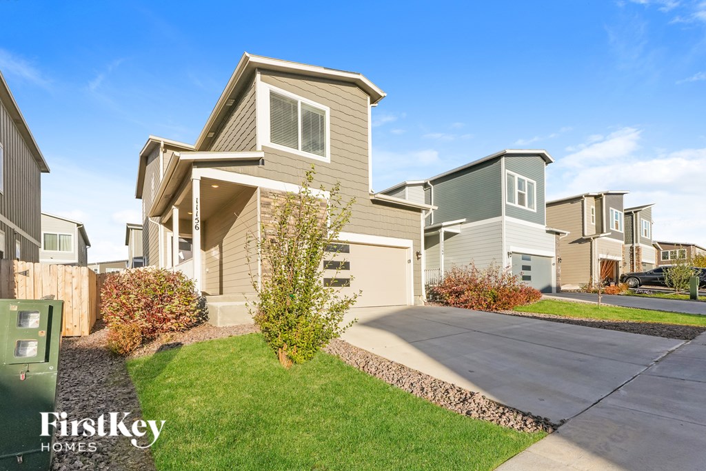 A house with a green lawn and a sign that says "FirstKey Homes".