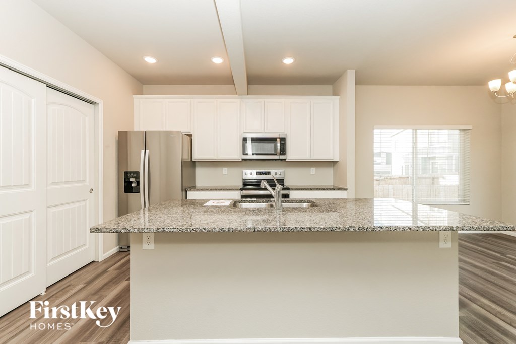 A kitchen with a granite countertop and a FirstKey Homes logo.