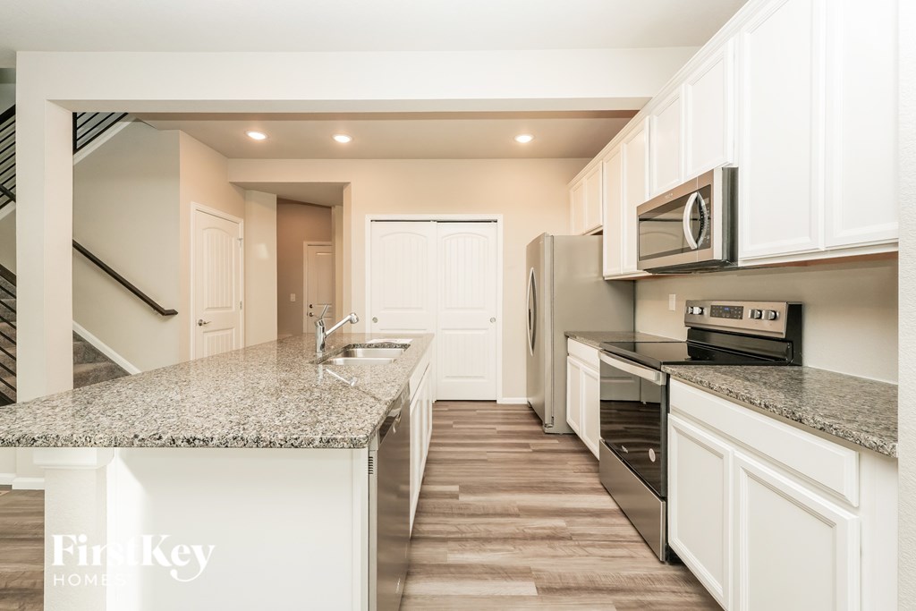 A kitchen with granite countertops and stainless steel appliances.
