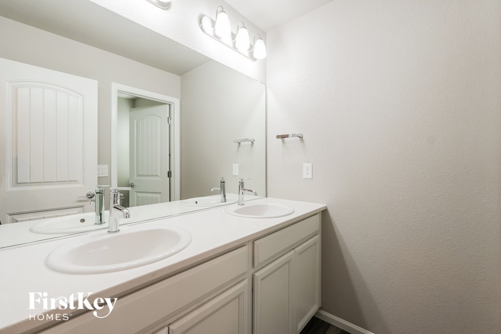 A bathroom with a double sink and a mirror.