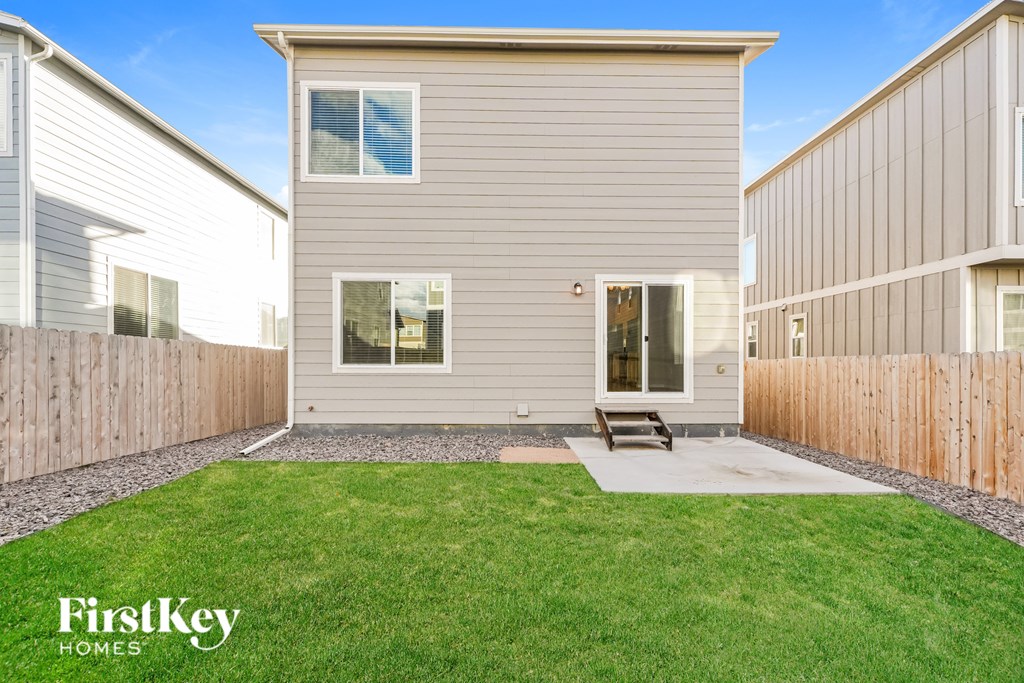 A house with a grey siding and a small porch.