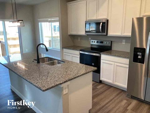 A kitchen with granite countertops and stainless steel appliances.