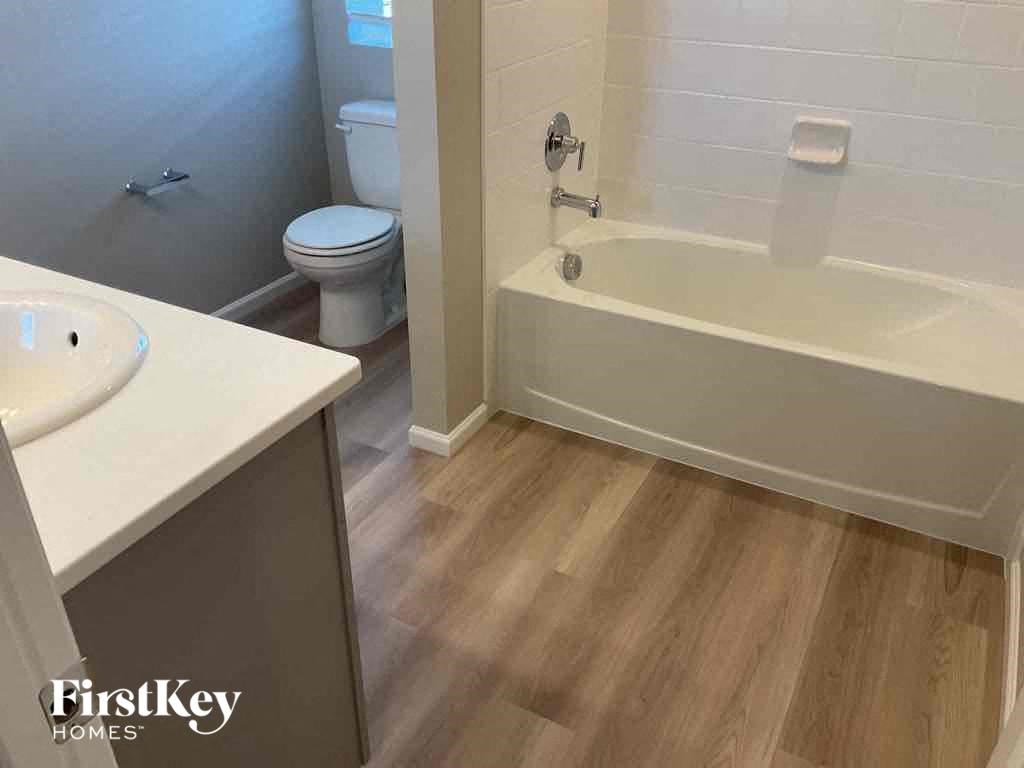 a bathroom with a bath tub and a sink and a toilet