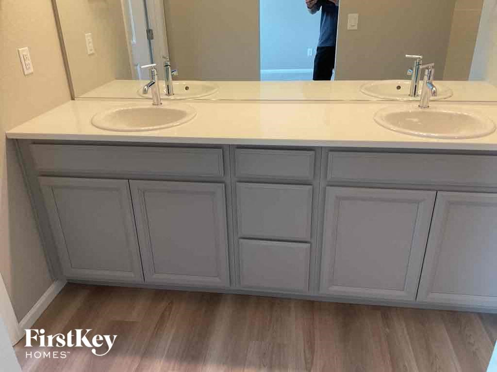 a white bathroom with two sinks and a mirror