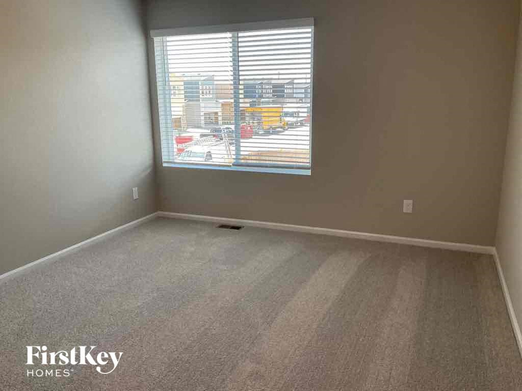 an empty room with a window and a carpeted floor