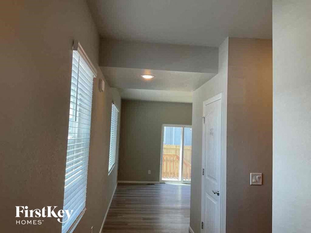 an empty hallway with a door to a balcony