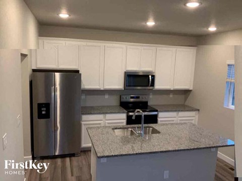 an updated kitchen with white cabinets and stainless steel appliances