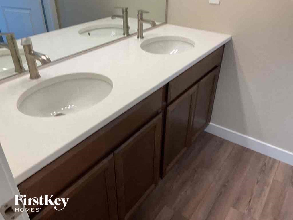 a pair of sinks in a bathroom with wooden floors