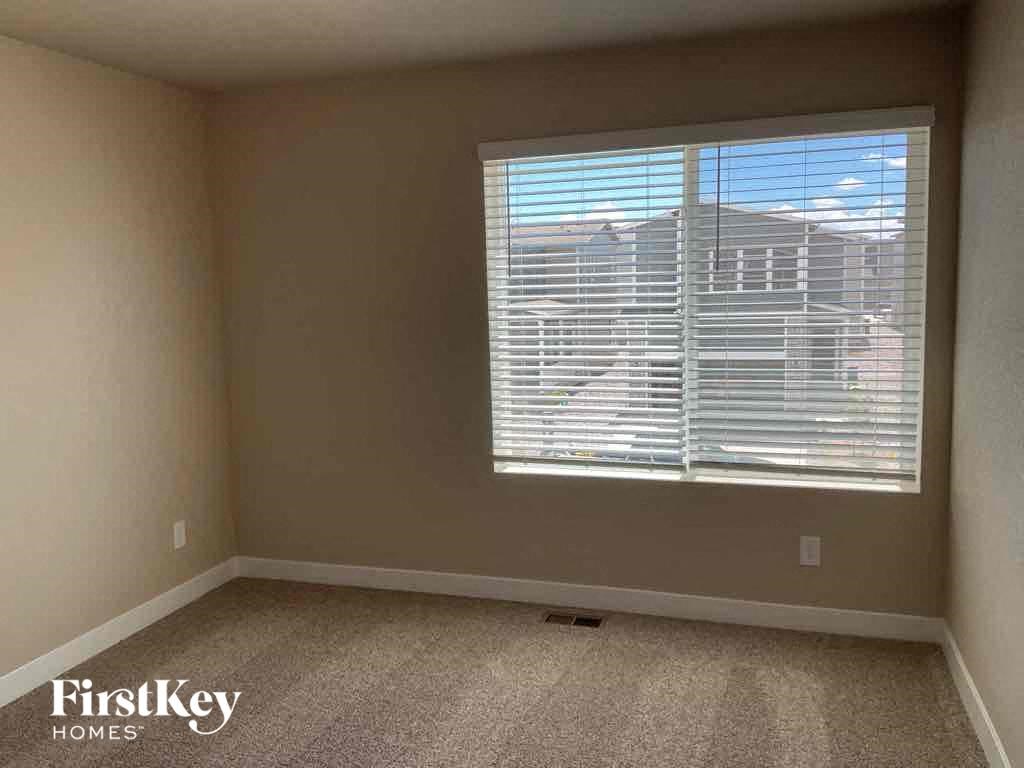 an empty room with a large window with blinds