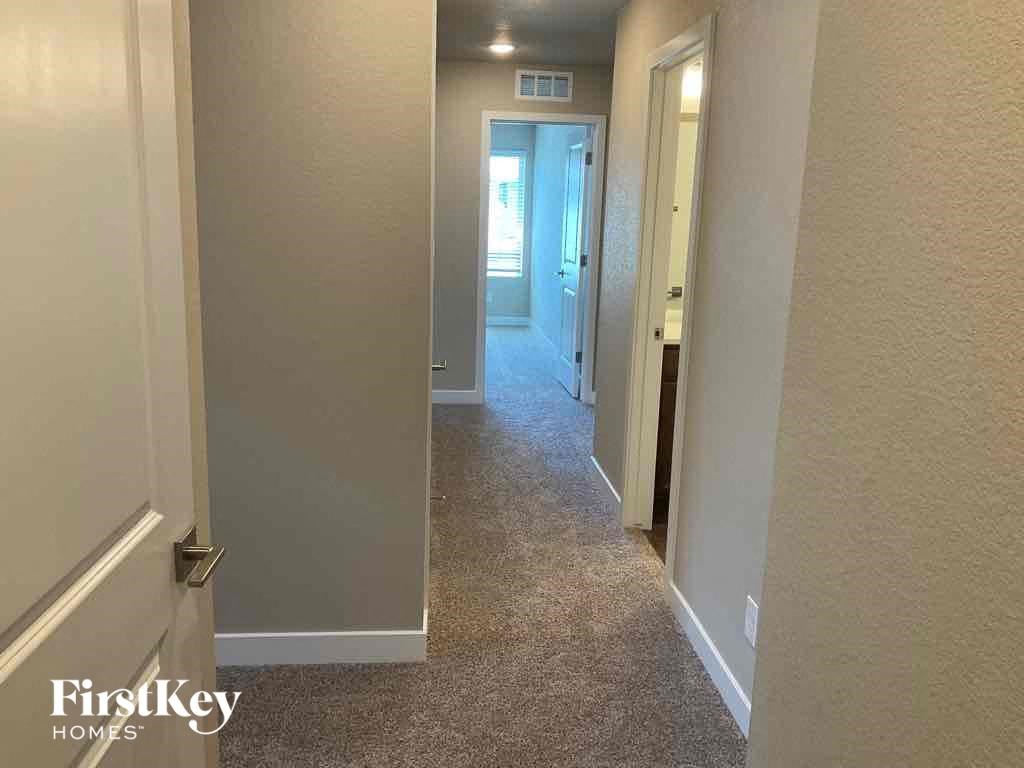 a hallway with a door to a bedroom and a hallway leading to a closet