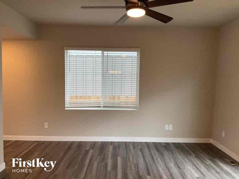 a living room with a window and a ceiling fan