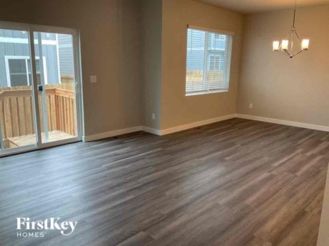 an empty living room with wood floors and a balcony