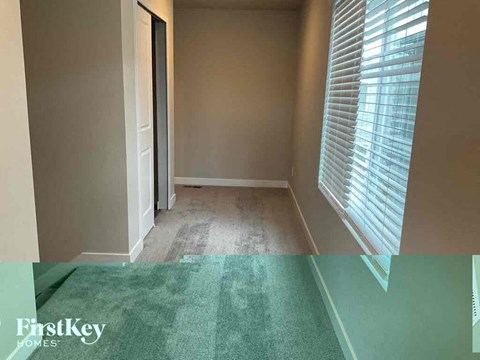 a empty room with a green carpet and a window
