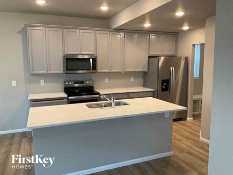 an updated kitchen with white cabinets and a white counter top
