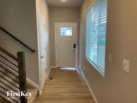 a hallway with a staircase and a door to a room with a window