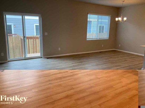 an empty living room with wooden floors and a sliding glass door