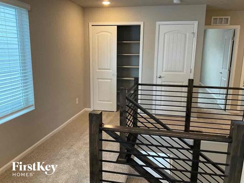 a stairway with a railing and a white door and a closet