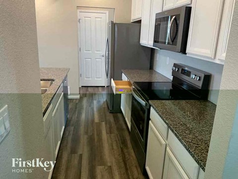 A kitchen with a black oven and a black microwave above it.