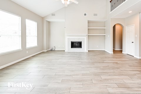 A spacious living room with a fireplace and a balcony.