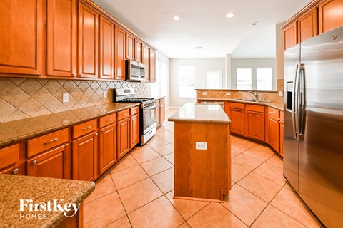 A kitchen with wooden cabinets and a tile floor.