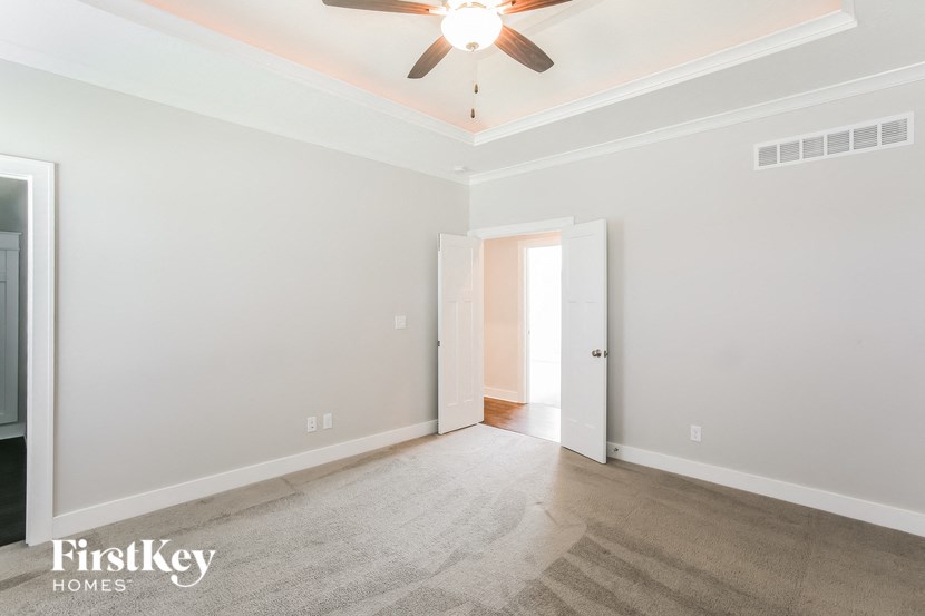 the living room of an empty house with a ceiling fan