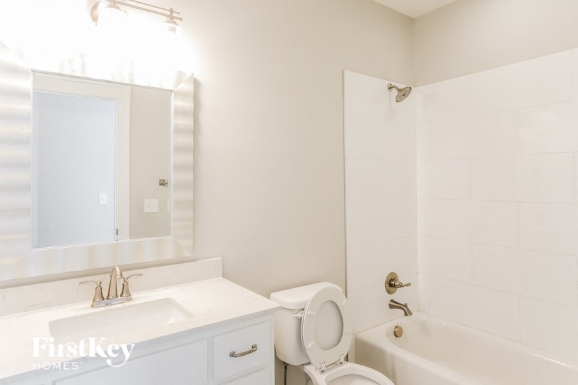 a bathroom with a sink toilet and tub and a mirror