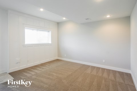 the living room of a new home with white walls and a window