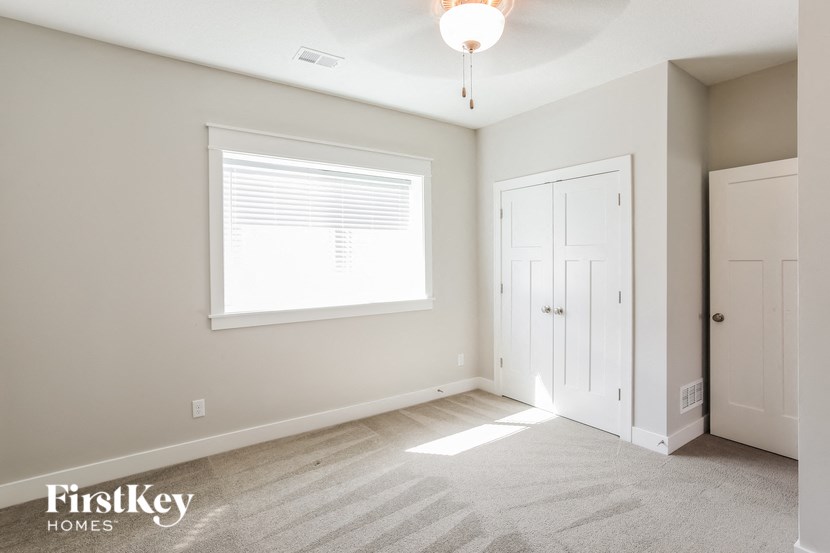 a bedroom with a large window and a white door