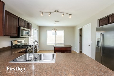 A kitchen with a sink and a refrigerator.