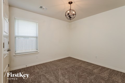 the living room of a home with carpet and a chandelier