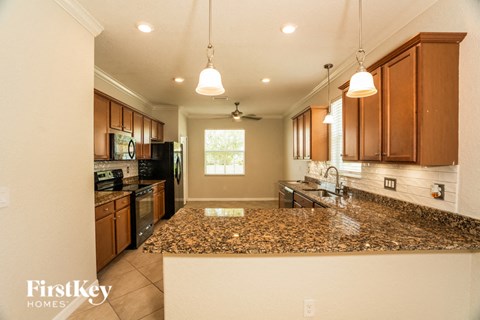 a kitchen with granite counter tops and wooden cabinets