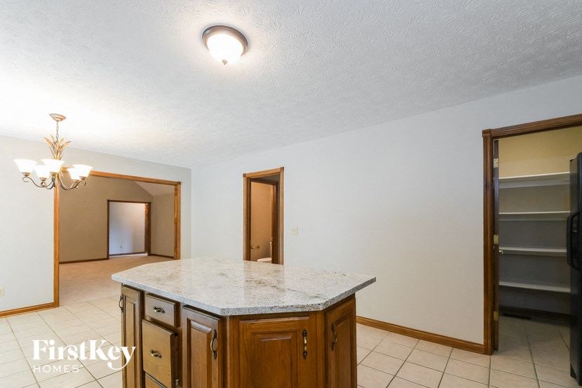 a kitchen with an island and a door to the living room