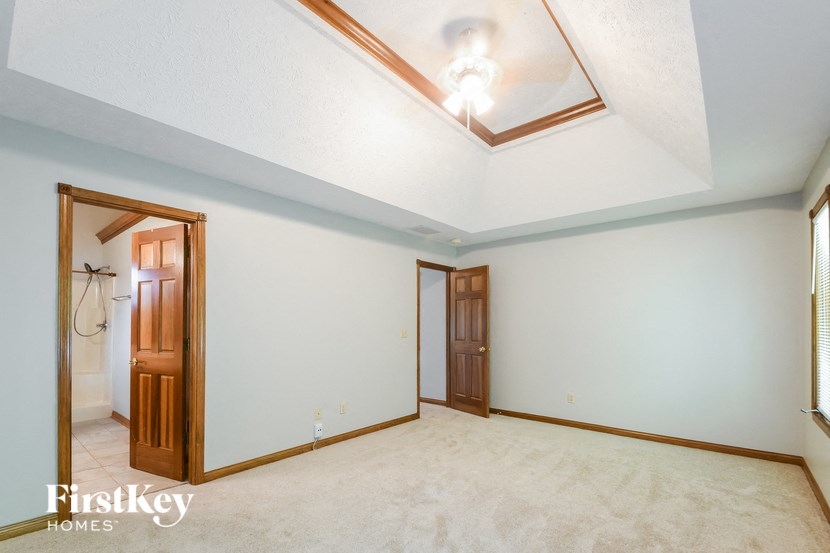 a empty room with a white ceiling and a door to a bathroom