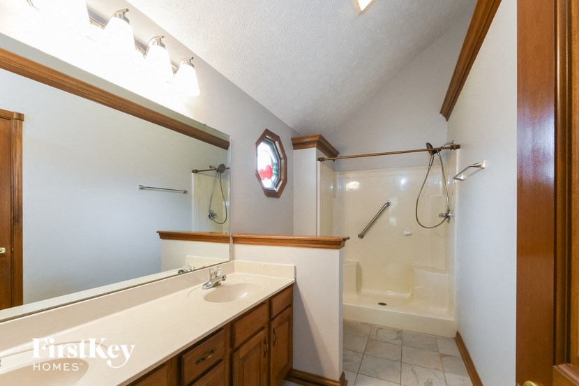 a bathroom with a shower and a sink and a mirror