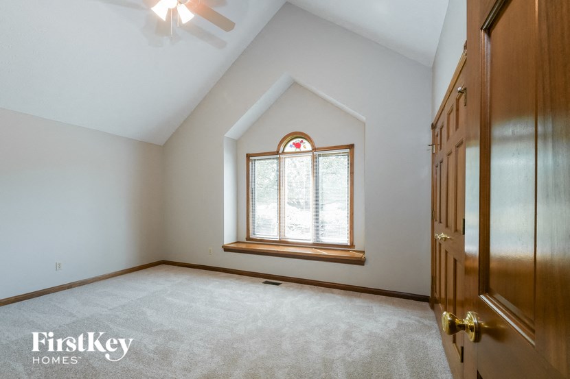 the master bedroom has a vaulted ceiling and a large window