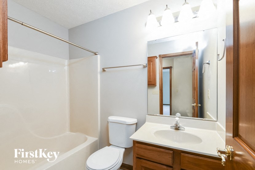 a bathroom with a sink toilet and a mirror