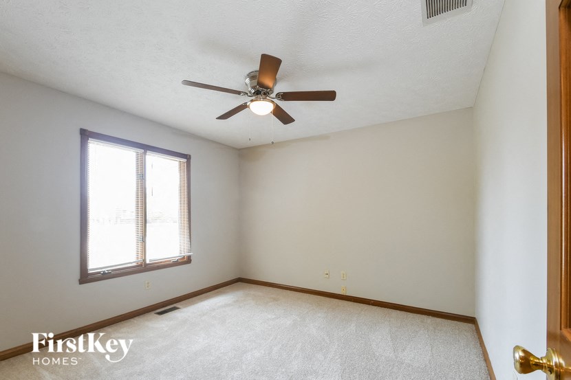 an empty room with a ceiling fan and a window