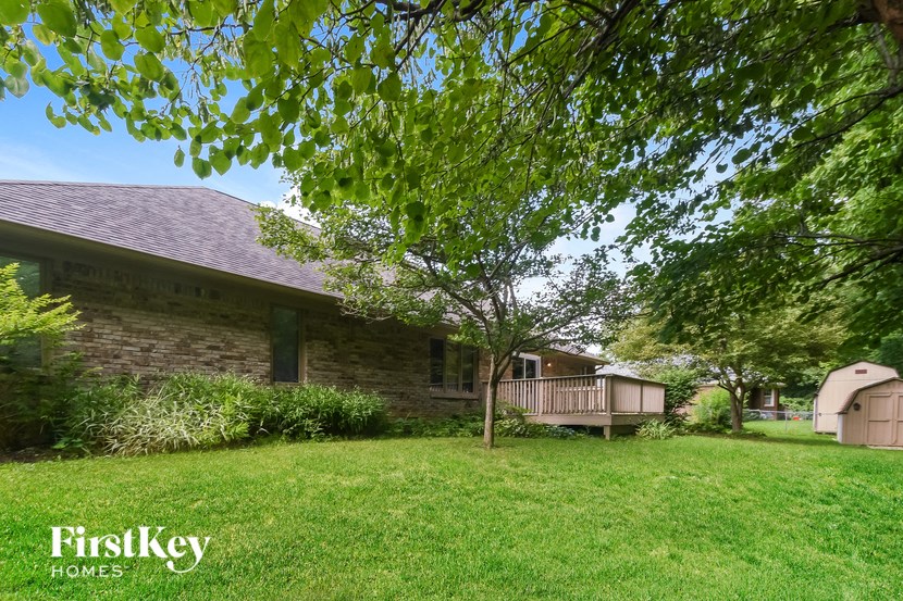 a house with a deck and a tree in the yard