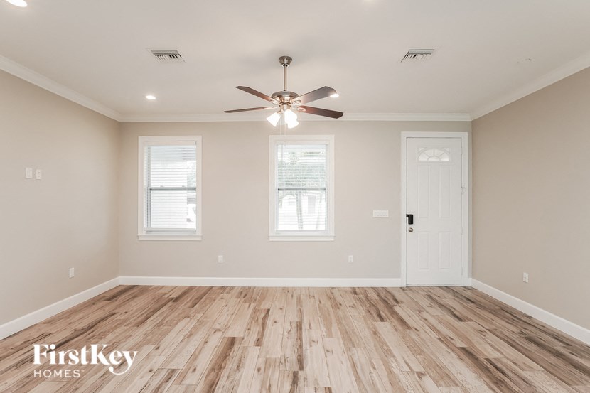 A room with wooden flooring and a ceiling fan.